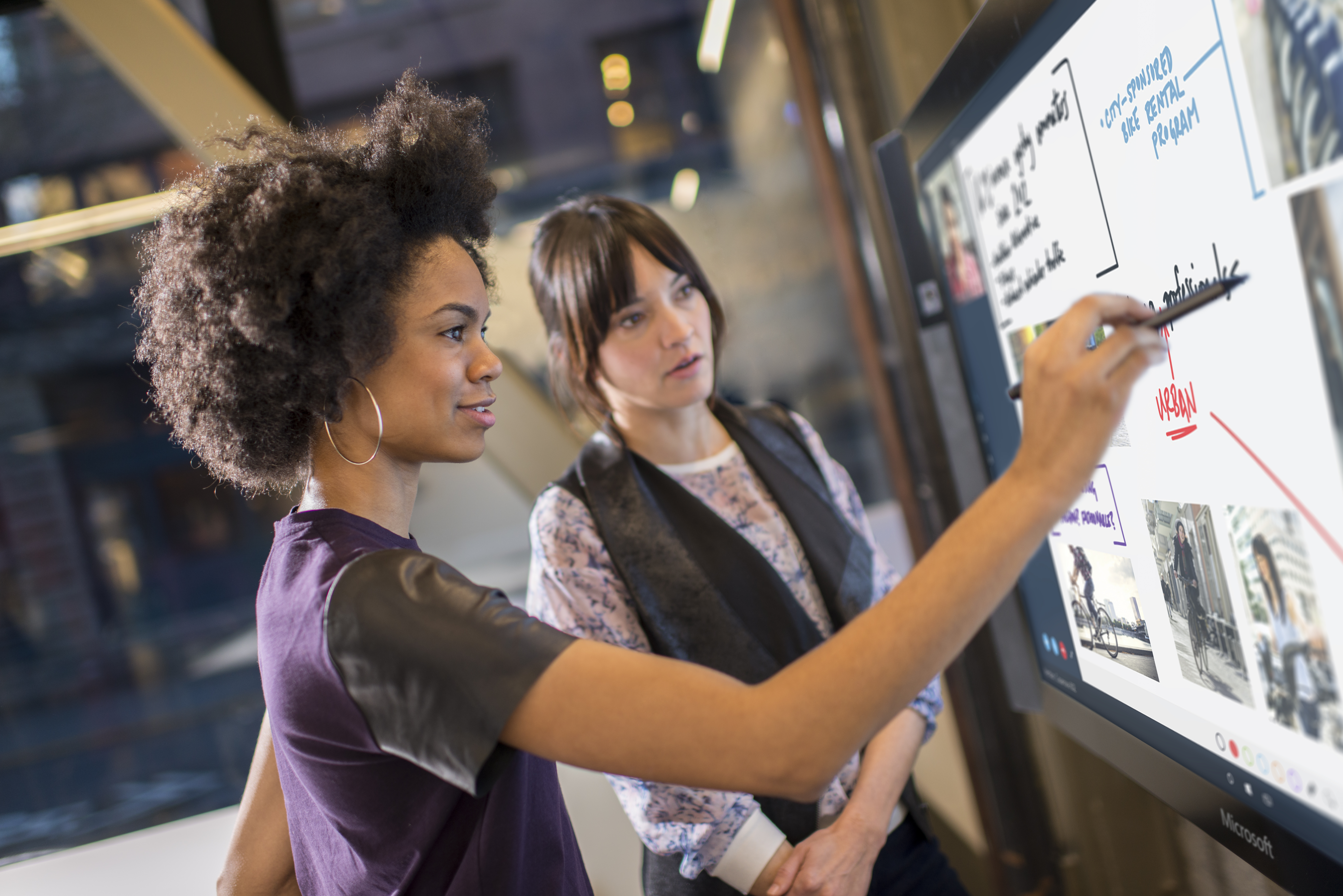 Woman writing on large touchscreen makewhatsnext