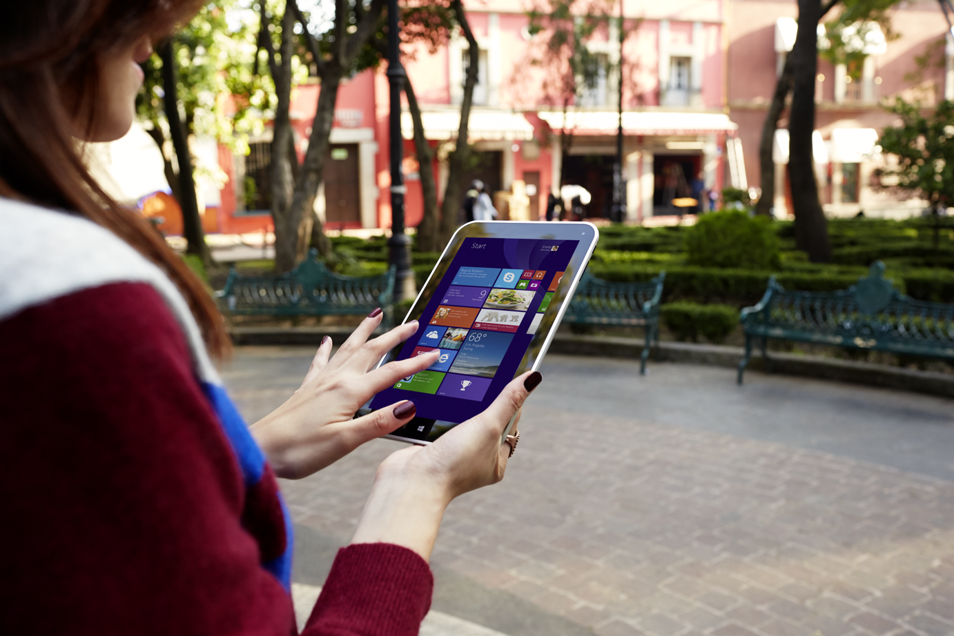 woman standing in park using surface tablet