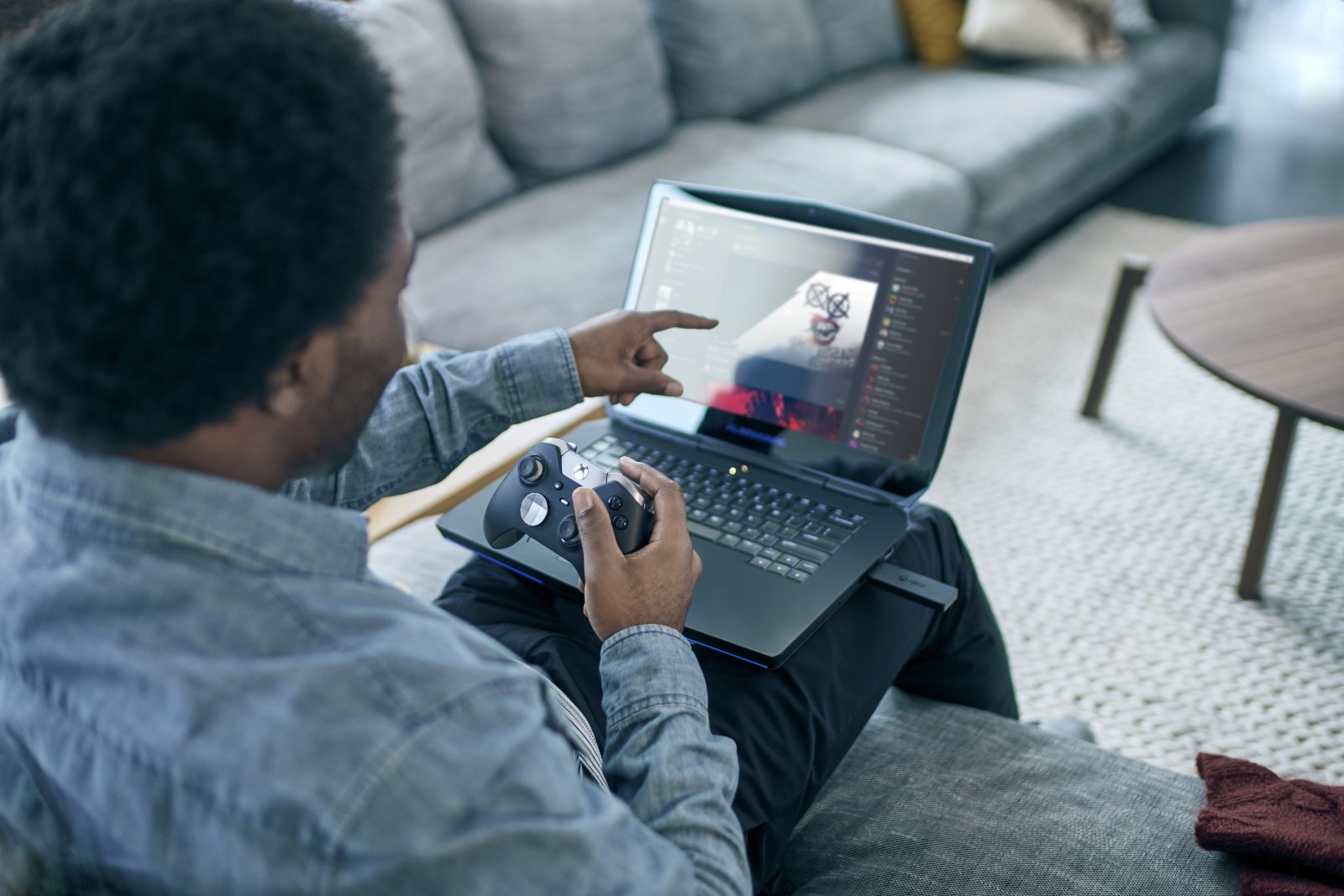 Man using Xbox controller and laptop to play games ID@Xbox