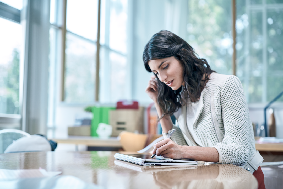 Woman using Surface Book on a table