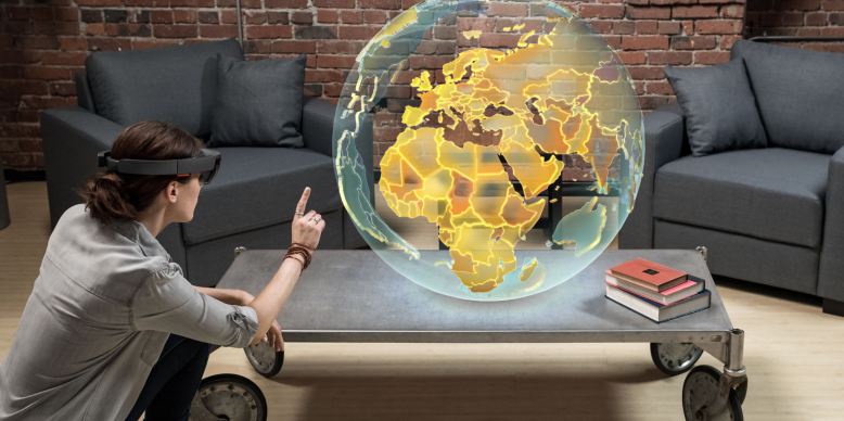 A man wearing HoloLens looks at a hologram of the Earth