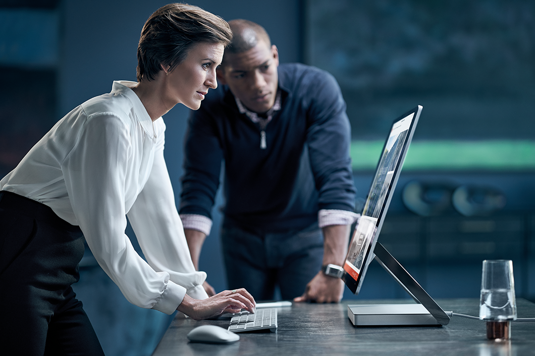 Man and woman working on a Surface Studio