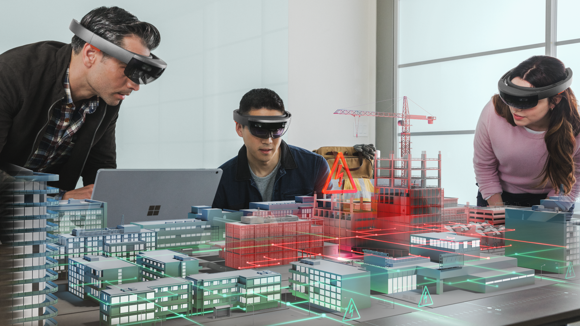 Three people wearing HoloLens looking at a virtual city on a table