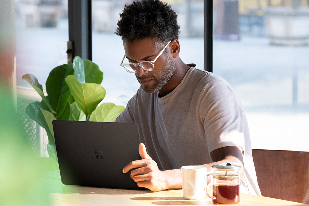 Man using Surface Laptop 2 in a cafe