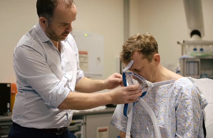 Doctor helping a COPD patient fit a breathing mask in a hospital