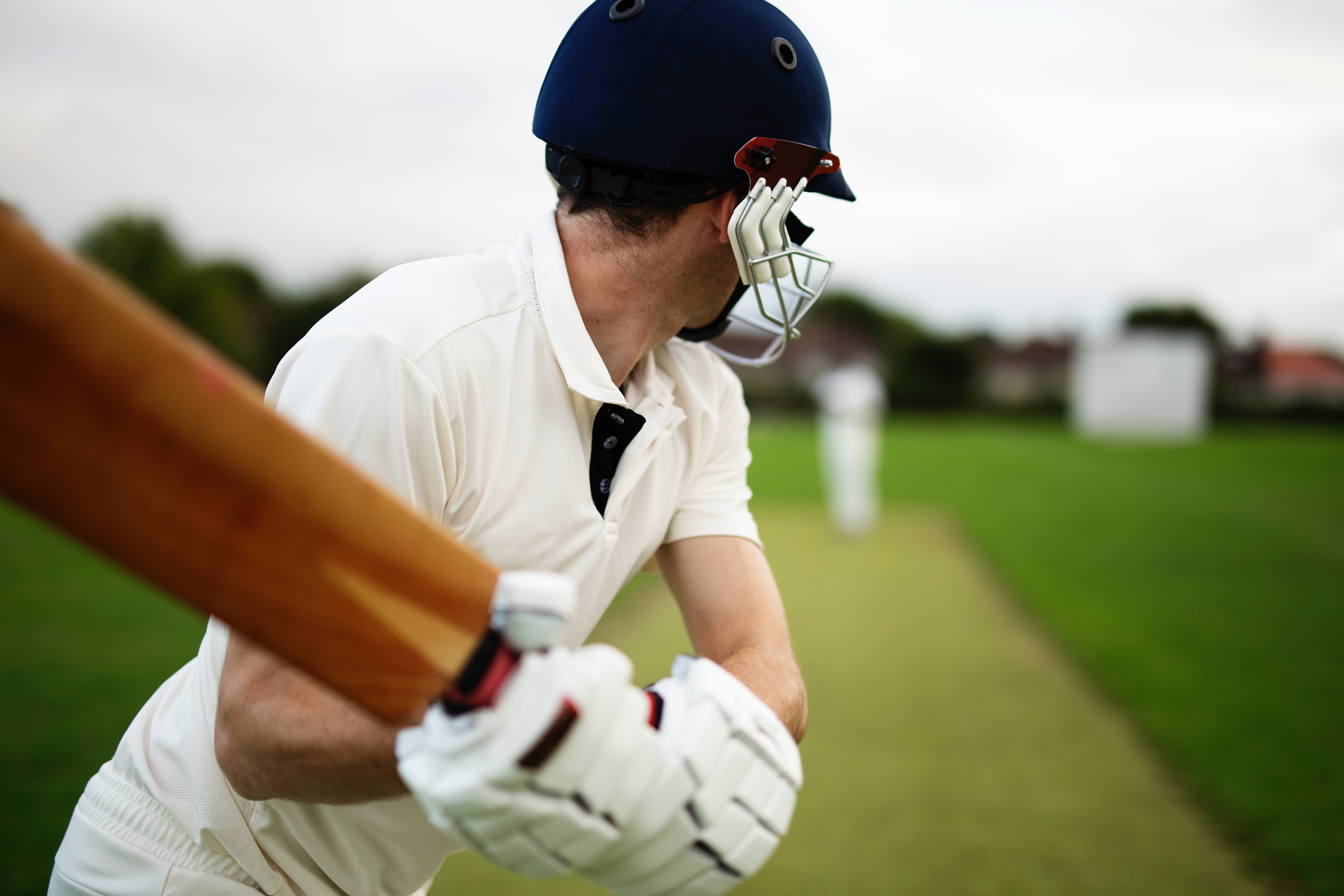 Man playing cricket, Batsman about to swing his bat at cricket ball