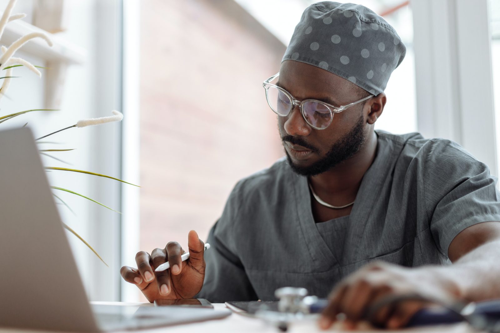 A healthcare worker types on a laptop
