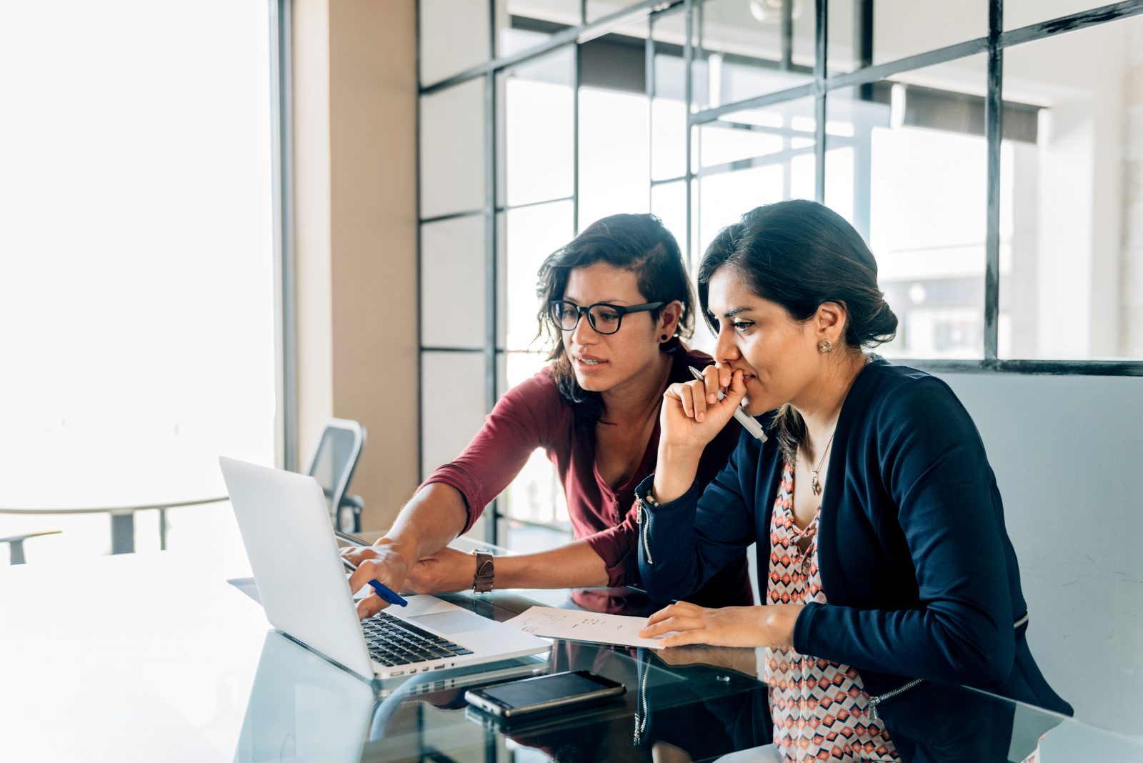 Two women look at a laptop
