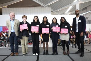 The winning team from the Old Palace of John Whitgift School with their winning certificates. From left to right: Mark Southgate, CEO of MOBIE, the team Nicola, Kayla, Shelise, Avni, Nishita, and architect Julian McIntosh.