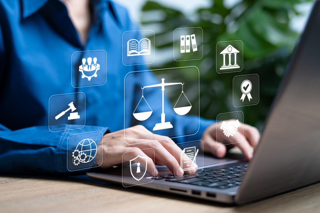AI-generated image of woman typing on a laptop with legal-sector-relevant icons floating above the keyboard