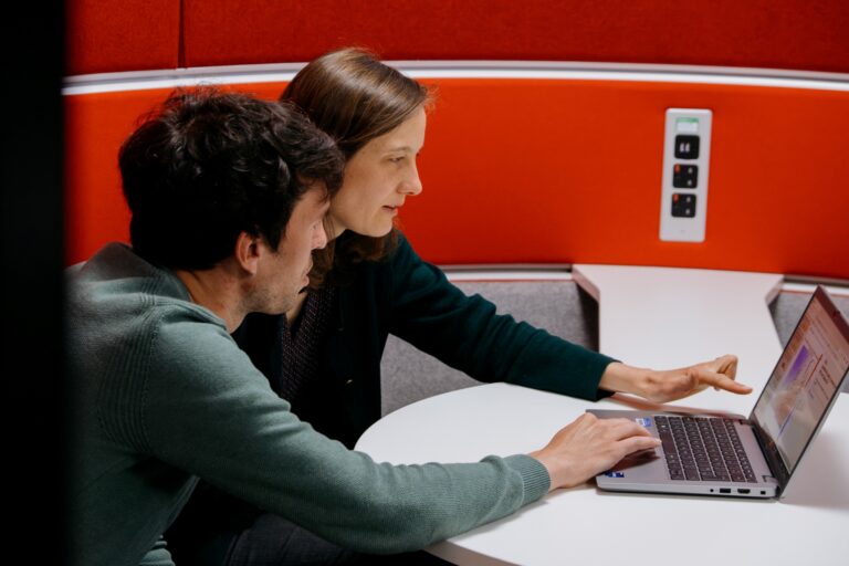 Two people from the Met Office looking at a laptop