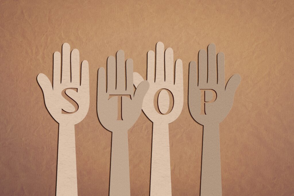 Cut outs of hands with the word STOP written on them
