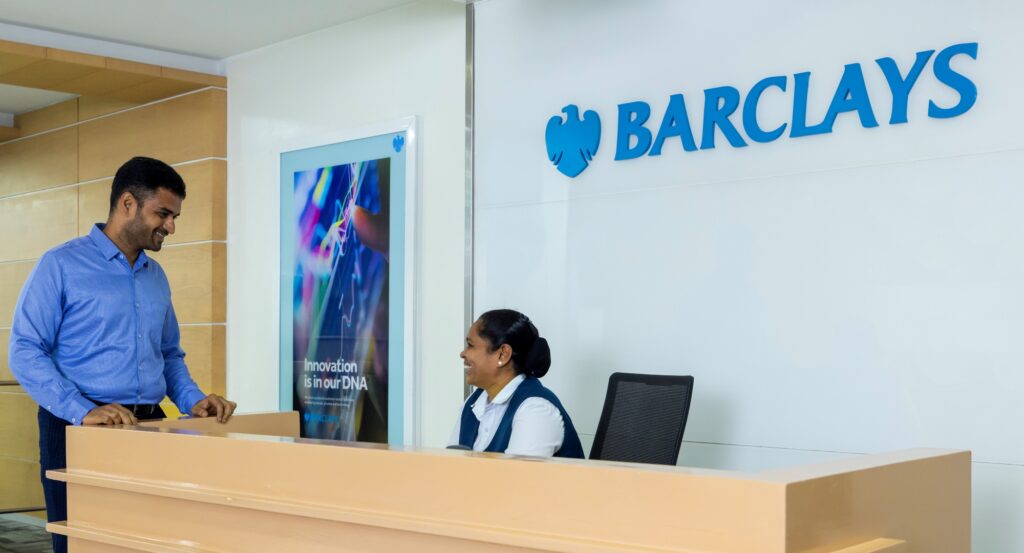 Two Barclays colleagues talking at a reception desk