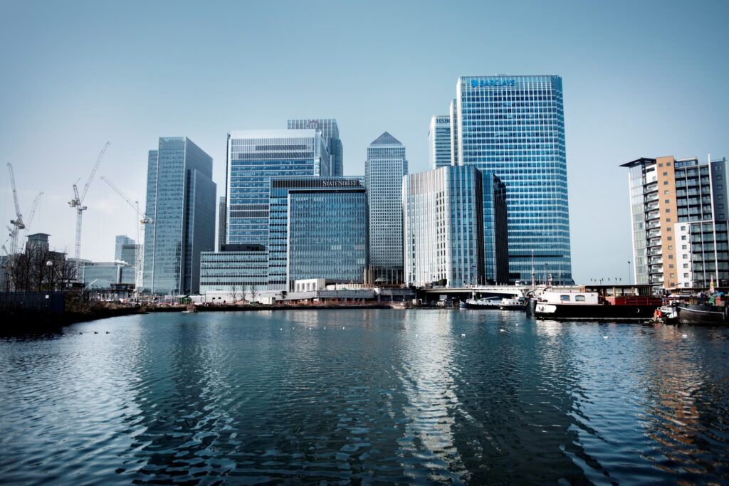 Shot of Barclays tower across water in amongst other skyrise buildings at Canary Wharf