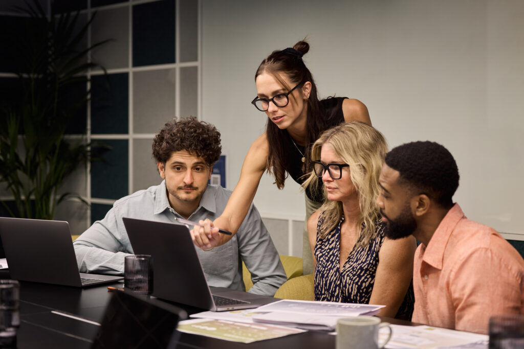 Work colleagues collaborating around laptop