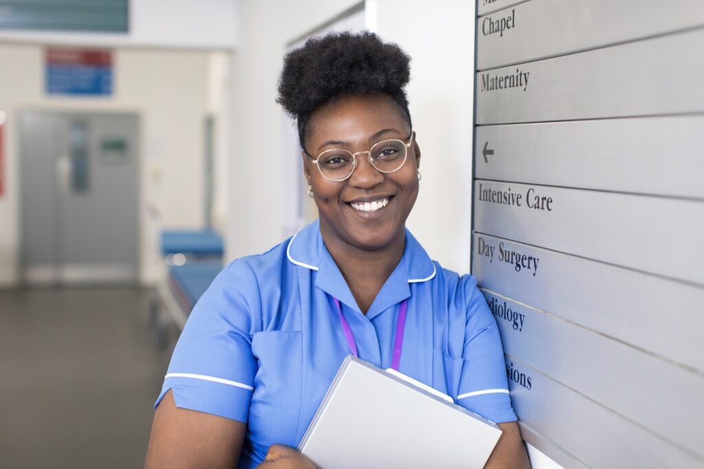 Nurse standing in front of hospital sign board
