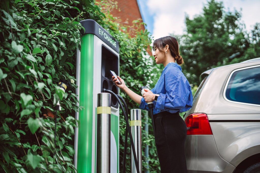 Woman paying at electric vehicle charging station