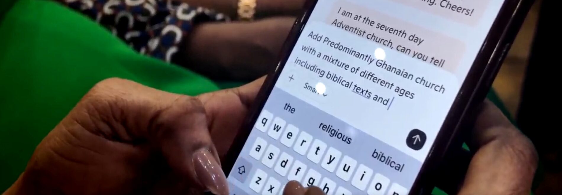 Close-up of a member of the South East London Community Seventh-day Adventist Church typing a prompt into Copilot on their phone