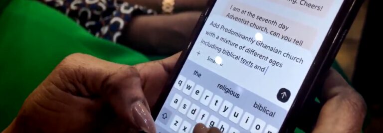 Close-up of a member of the South East London Community Seventh-day Adventist Church typing a prompt into Copilot on their phone