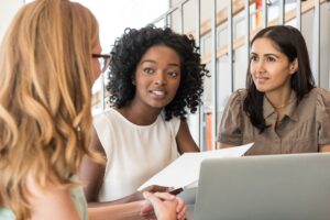 Three women in conversation in office environment - for TechHer feature