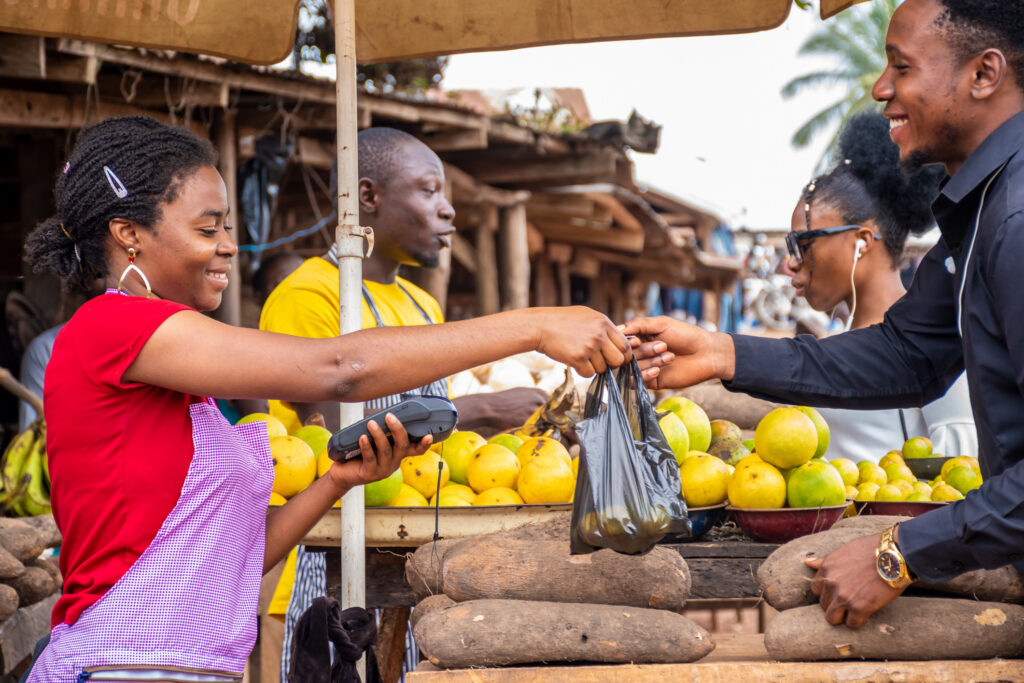 People buying and selling in an African food market